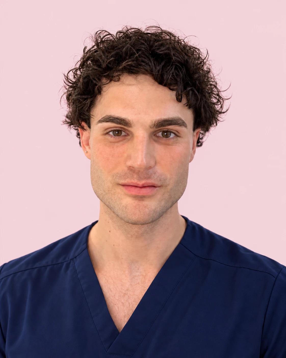Dr Noah Losa, smiling, in navy scrubs